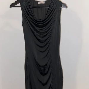 Svart klänning - Svart klänning med fantastisk passform. På framsidan är den dräperad vilket ger en fin figur. 