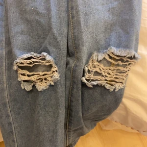  jeans med hål - Jättefina jeans med hål från bohoo. De är riktigt fina men behöver tyvärr sälja de då de är alldeles för stora i midjan. Fint skick och bara testade!
