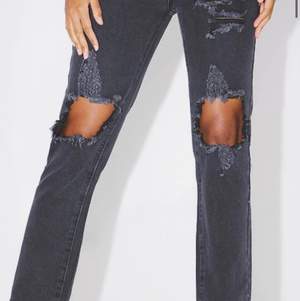 Washed black distressed jeans från Pretty Little Thing. Helt oanvända med taggen fortfarande kvar. Säljer pga för stora. Mäter ungefär 40 cm rakt över midjan. Stora i storleken.