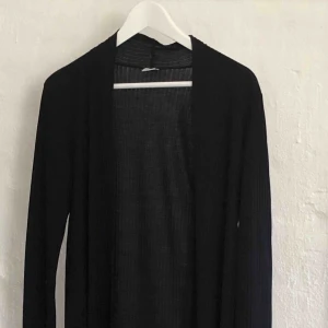  - Svart lång kofta. Randig i tyget.