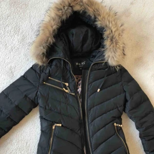  - Hollies jacka. Vanligtvis är jag 34 i storlek men 32 på denna passade bättre. Snygg höst/vinter jacka med foder och gulddetaljer. Avtagbar krage. Inner och ytterfickor. Fyllning dun/fjädrar 80/20. Säljes pga för lite användning. Ordinariepris: 3 998kr 