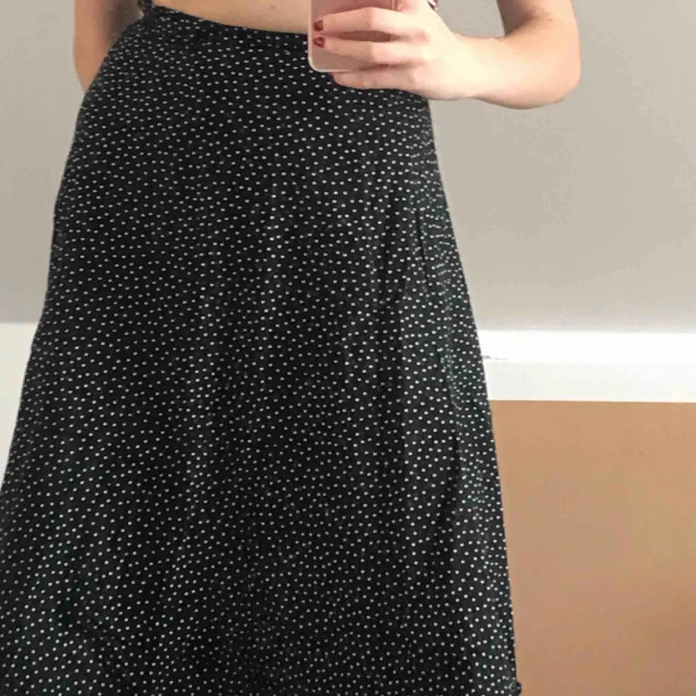 Prickig midi-kjol som räcker till knäna. Mörkblå, nästan svart, trendig. Kjolar.