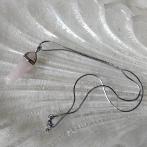  - Halsband med kristall-berlock. Gissningsvis är det en rosenkvart, då den är köpt utomlands på en marknad vet jag inte exakt.