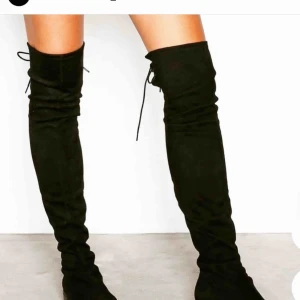  - Overknee stövlar. Svarta i mocka imitation med snörning baktill. Andvända 3 ggr. Så är som nya 