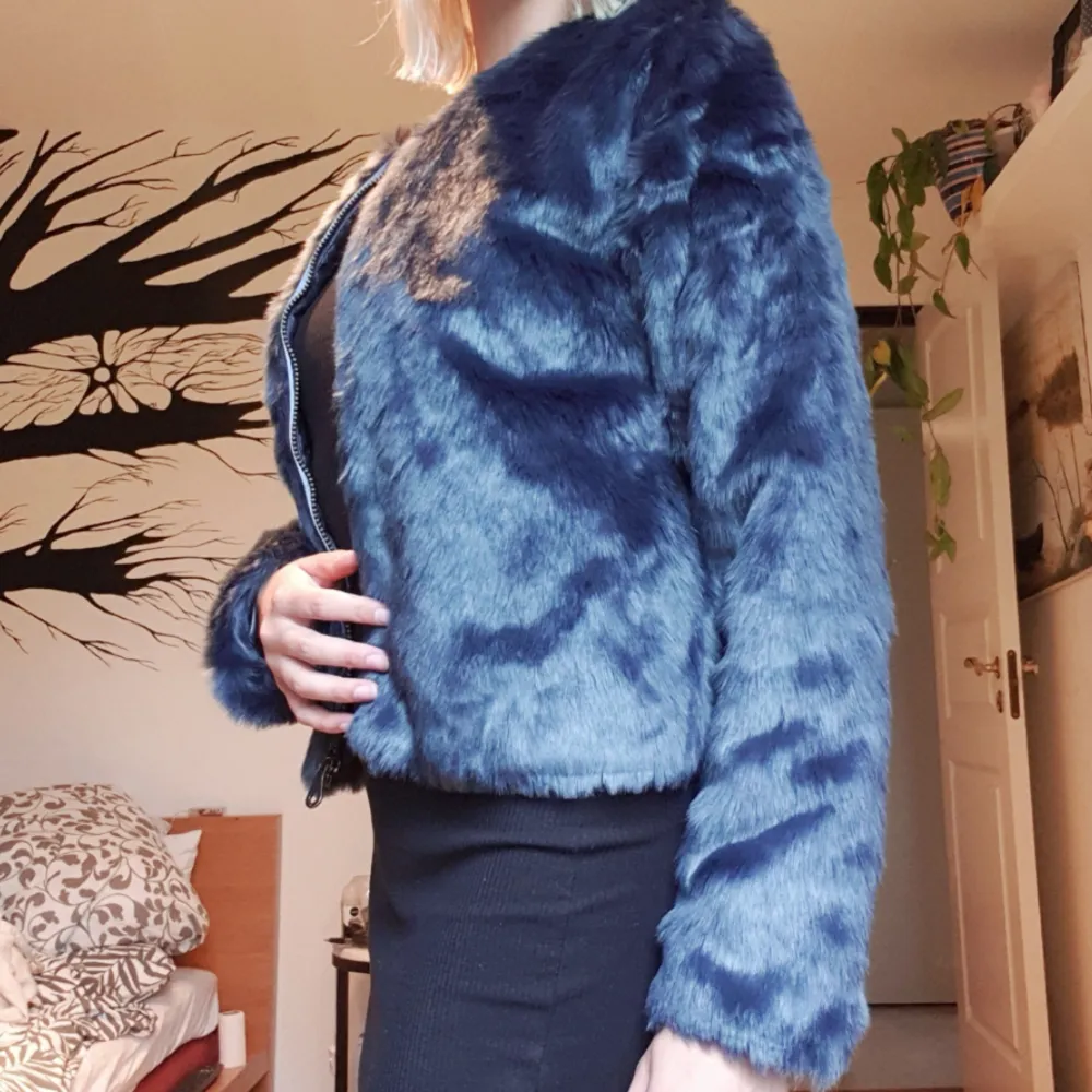 Kort faux fur jacka med dragkedja. Blå färg. . Jackor.