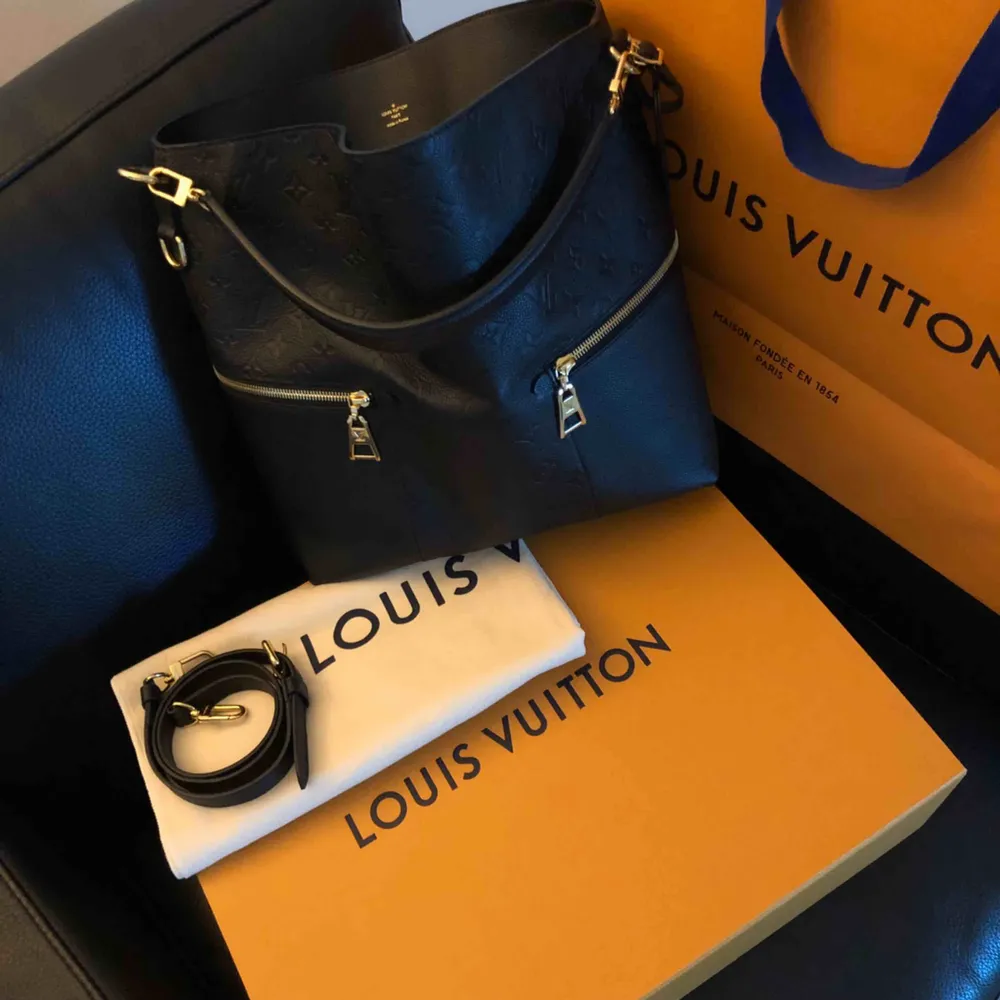 Louis Vuitton Mélie  Medföljer kartong, kasse, tygpåse, intyg & kvitto.  Mer info: https://us.louisvuitton.com/eng-us/products/melie-monogram-empreinte-nvprod260001v. Väskor.