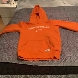  - En fin orange hoodie från peak storlek 130