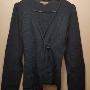  - Riktigt fin, virkad kofta med omlott knytning och knapp. Marinblå och v-ringad.