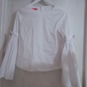  - Super snygg klassisk blus med en twist från Catherine Malandrino, knäpps i ryggen, vit strlk XS. Helt ny och bara legat i garderoben. Nypris $ 88 76% Bomull,21%Nylon, 3%Spandex   Har en stor garderob och vind rensning :) Kommer lägga ut mer saker :)  Leverans sker med Schenker eller Postnord spårbar(om frakten understiger det angivna så returerar jag mellanskillnaden) OBS! Spricka på lins därav svarta prickar på vissa kort.