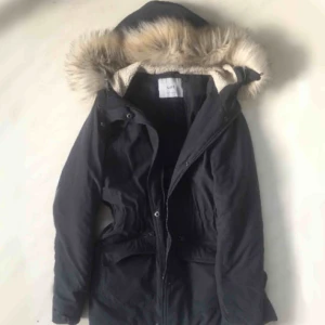  - Vinterjacka från dust i jättefint skick. Sparsamt använd. I mjukt mockaliknande material. Når en bit ner på låren och har lite resår i midjan. Färgen är mörk grå/blå. Frakt tillkommer. 