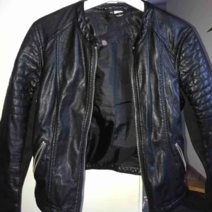  - Sparsamt använd skinnjacka (ej äkta) köptes i våras på HM och är använd ett fåtal gånger. Skönt matrial med tygdetaljer på underarmarna och ”nitdetaljer” vid kragen. 