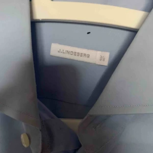  - Helt oanvänd skjorta från J.Lindeberg. Dock har det blivit en liten liten fläck (se sista bilden) men det ska nog inte vara några problem att få bort. 