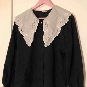 En svart vintage skjorta i mjukt material med en vit krage, gjord i Bulgarien. Inga lösa trådar eller lösa knappar. (Inte inklusive frakt, det står köparen för!)