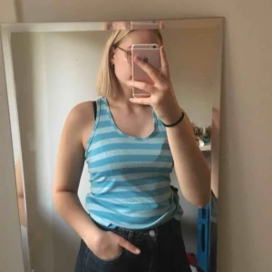  - Träningsstopp med brottarrygg. Randig mörkare och ljusare blå. Luftigt material. 