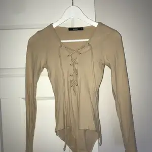 Body i beige färg från Bikbok. 