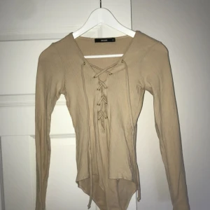  - Body i beige färg från Bikbok. 