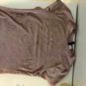 Ljusrosa t-shirt med diskret broderad text