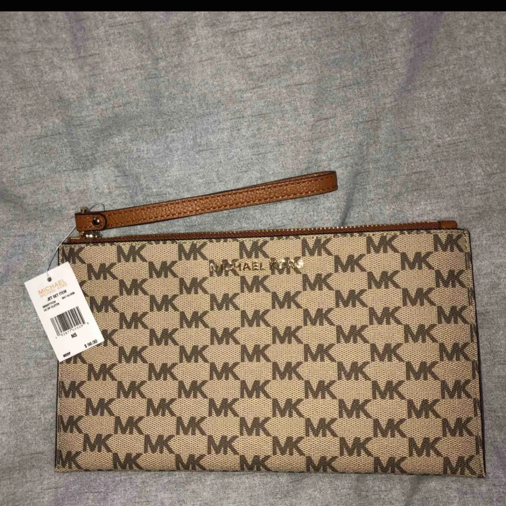 Helt ny clutch från Michael Kors. Frakt ingår i priset, kan även skickas med spårning så du vet vart den är och så att den inte kommer bort! Kan bevisa att den är äkta om så önskas, köpt för ca 950kr. Laukut & Käsilaukut.
