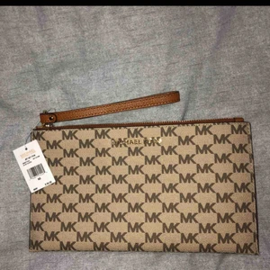  - Helt ny clutch från Michael Kors. Frakt ingår i priset, kan även skickas med spårning så du vet vart den är och så att den inte kommer bort! Kan bevisa att den är äkta om så önskas, köpt för ca 950kr
