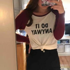  - Tunn långärmad tröja med texten ”Do it anyway”. Vit tröja & vinröda ärmar.