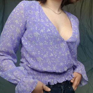  - Fiiiin lila halvgenomskinlig blus/topp från Bikbok med djup V. Finns en liten knapp på framsidan. Najs till vår/sommar 👾🧜‍♀️💜🍆🍇🌌  Betalning via swish, kan mötas upp i malmö, annars står köparen för frakten.