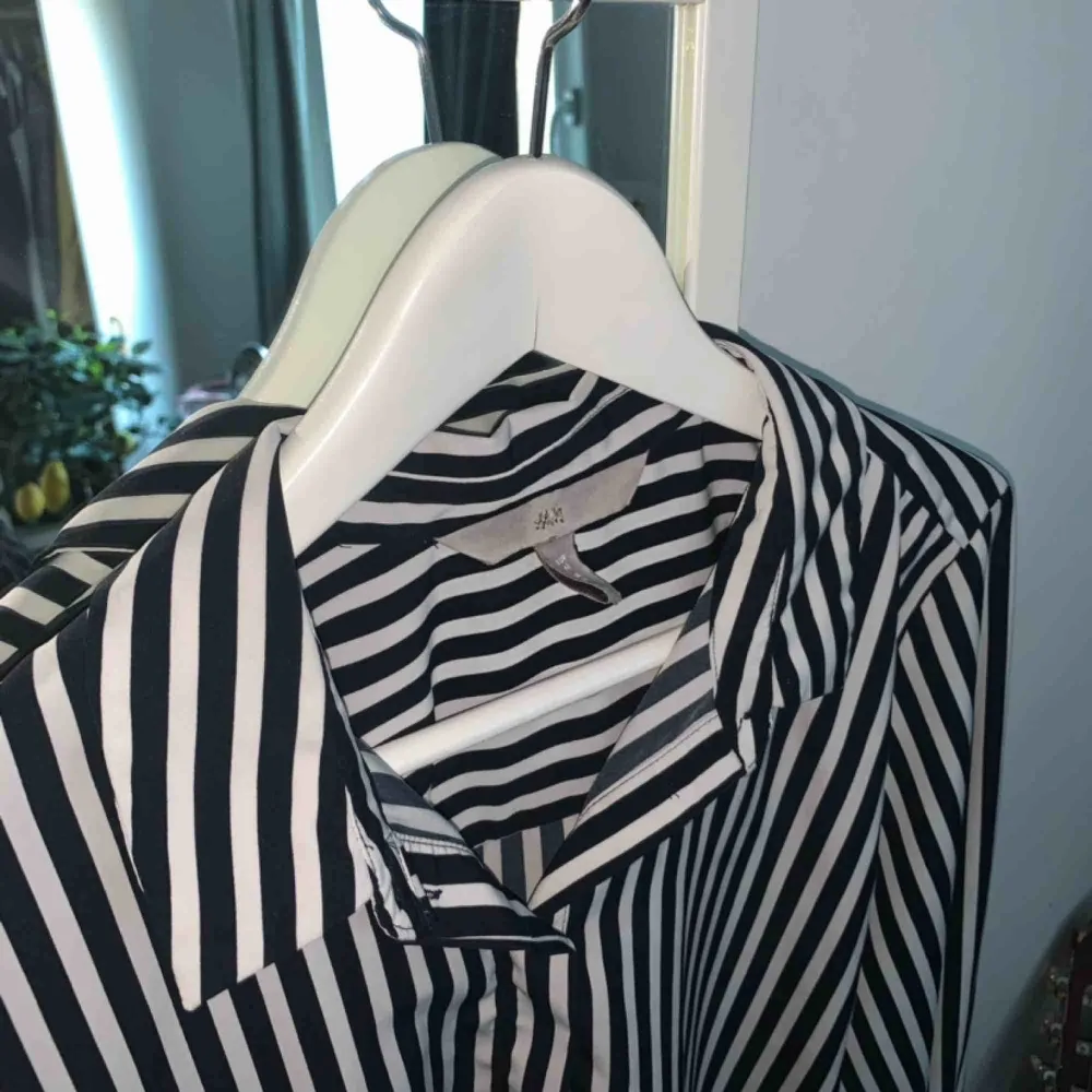 En svart och vitrandig skjorta i storlek L från h&m.💜. Skjortor.