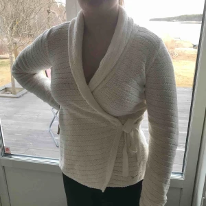  - Creme vit kofta med knytning från Bondelid. Minimalt använd. Frakt tillkommer 