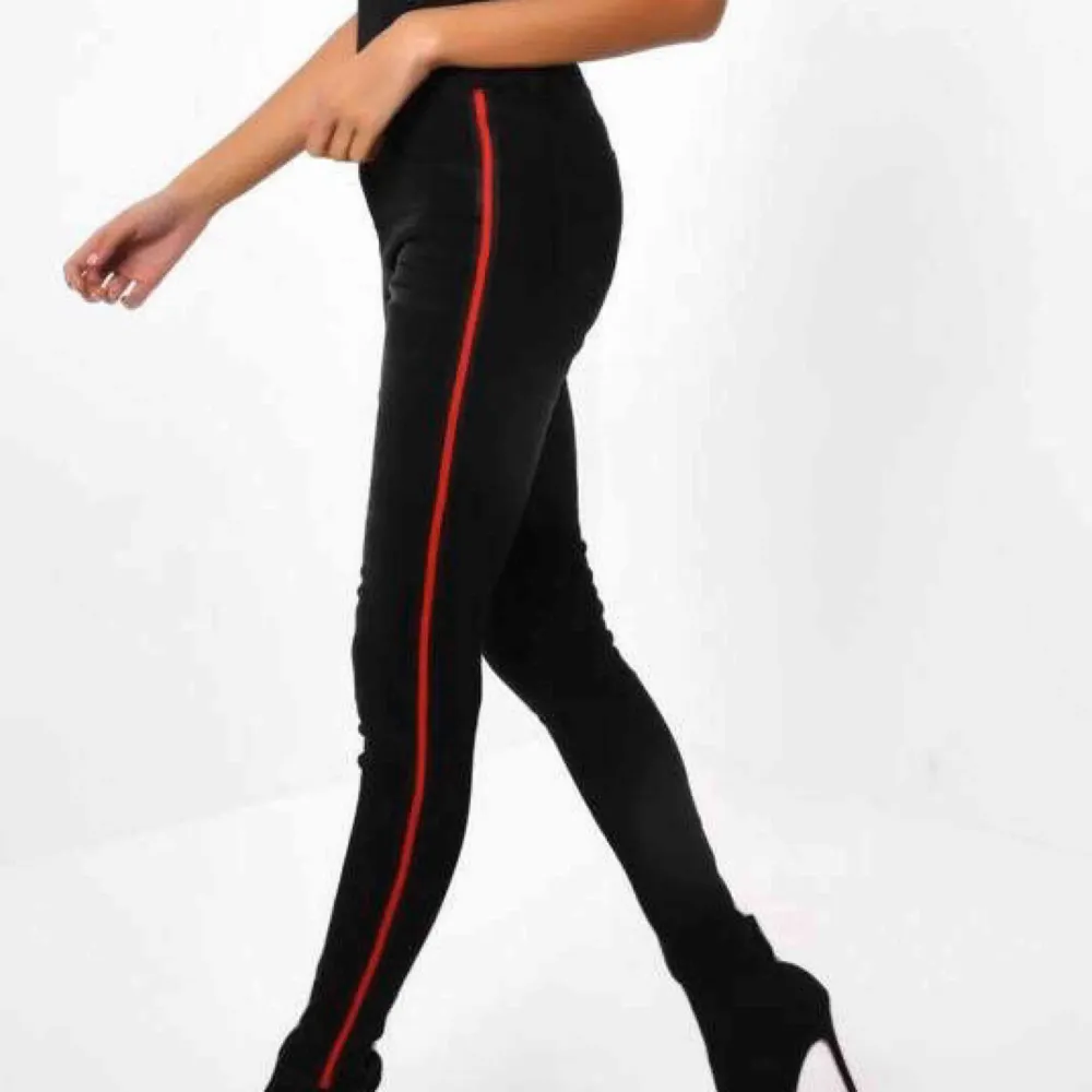 Svarta jeans med cool röd stripe längs benen. Använda ett fåtal gånger. Högmidjade och slimfit. Köpta från Bershka. Frakt ingår ej och fler bilder kan skickas vid intresse. . Jeans & Byxor.