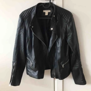  - Svart fake-skinn jacka i biker stil från HM. Storlek 38 men passar även mindre storlekar beroende på hur löst man vill att den ska sitta. Kan hämtas i Sundbyberg eller frakta!