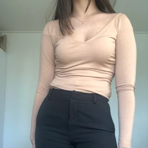 V-ringad tröja  - Beige/rosa tröja från Nelly. Använd endast en gång. Frakten ingår 🤩