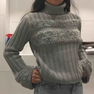 - En unik och cool tjocktröja med hög krage. Med detaljer över bröstet och på ärmarna. Passar storlekarna XS-M beroende på hur man vill att den ska sitta