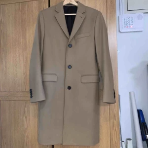 H&M Rock i ullmix  - Rocken är från H&M premium quality. En rock i ullblandning. Bröstficka, framfickor med lock samt två innerfickor. Nypris 1499kr. Använd endast ett fåtal gånger, utmärkt skick.