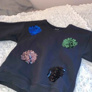  - En svart tjock tröja med paljett detaljer på. Resår vid hals armslut och längst ner har använt nära få gånger. Frakt tillkommer👍🏻