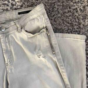 Ljusgrå jeans från Penelope Zip. Fint skick, använda ett fåtal gånger. Storlek 27, slim fit med stretch. Blixlåsdetaljer och slitningar. 150 kr plus frakt. 