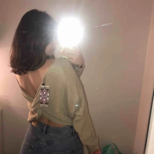  - En beige stickad tröja från boohoo med öppen rygg. Prislappen är fortfarande kvar och oanvänd.  Det står att storleken är en ”S/M” men skulle säga att det är en M.