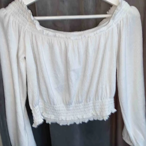  - Vit långärmad off shoulder topp som fungerar jättebra till sommaren och våren. Fungerar även till uppklädningar. Använd en gång och i ett superfint skick.