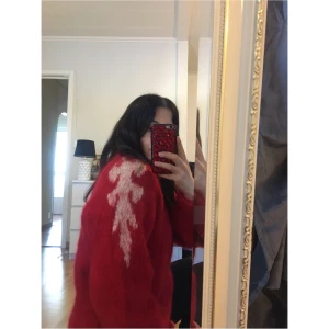 Röd stickad tröja  - Super unik och snygg stickad röd tröja med ljusrosa mönstren på axlarna ner mot armen. Finns ingen storlek men skulle säga att den är en medium. På någon som är Size small, som jag är, blir den snygg oversized. Perfekt till vintern ✨💋 