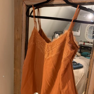Spetslinne  - Säljer detta orangea spetslinne/ topp pga för stor storlek       Nyskick, aldrig använt.                                                           Linnet har justerbara band vilket gör att storleken går att justera!                                                                                    Kan antingen skicka eller mötas upp i Stockholms innerstad🌟