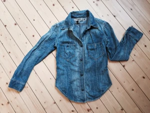  - Supersnygg jeansskjorta från Levis. Säljer den med sorg då den tyvärr är för liten för mig. Storlek S men snarare en XS. Tight passform. Bra skick, endast använd ett fåtal ggr! 
