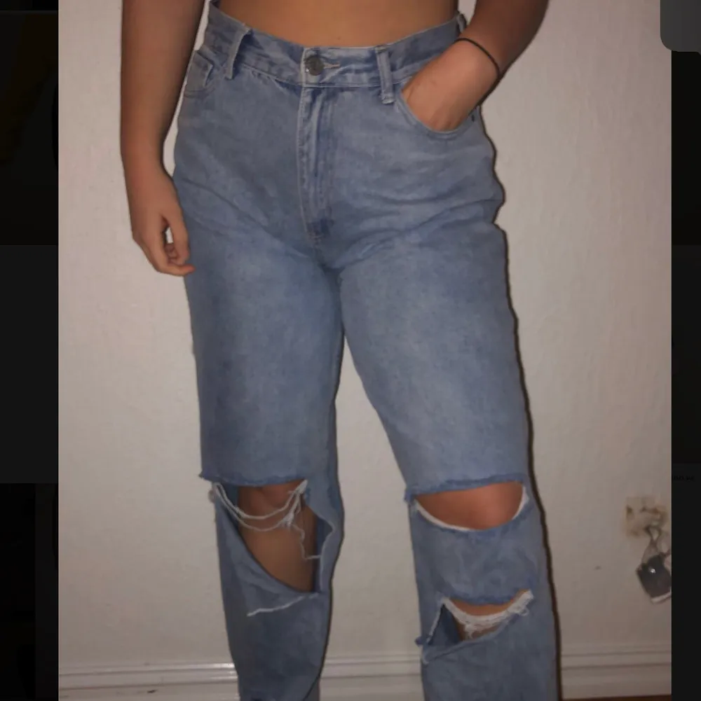 Ett par blåa jeans med hål vid knäna och ner. Nytt skick då dem aldrig är använda. Köpta från boho, storlek 42. Köparen står för frakten. . Jeans & Byxor.