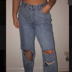 Boho jeans med hål - Ett par blåa jeans med hål vid knäna och ner. Nytt skick då dem aldrig är använda. Köpta från boho, storlek 42. Köparen står för frakten. 