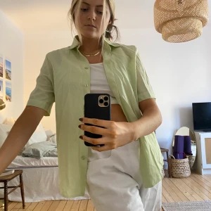 Söt blus/skjorta till våren stl L - Säljer min jättefina skjorta/blus i grön pastell. Så fin att knyta eller ha över en polotröja. Från second hand, väldigt fint och tunt tyg i bra skick! 