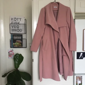  - I princip ny, superfin kappa från jaqueline de yong. Använd 2 gånger. Säljes då färgen inte var min grej, tyvärr. Färgen är lite dustrosa.  Två fickor och knytskärp i midjan. 