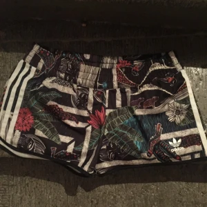  - Snygga adidas shorts, endast använda en gång. Ballt djungelmönster, glansigt material, klassiska stripes på sidorna. 