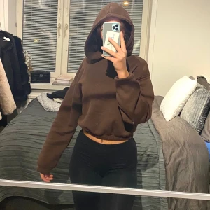 BRUN CROPPAD HOODIE - Jättefin brun hoodie som är väldigt trendigt just nu. Croppad och slutar vid naveln. Skönt material och har även en luva. XS/S