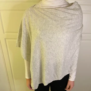 Poncho - En jättefin grå/vit poncho, ONESIZE! Ljuset får den att se lite gul ut, det är den inte! Minst 60kr+frakt!