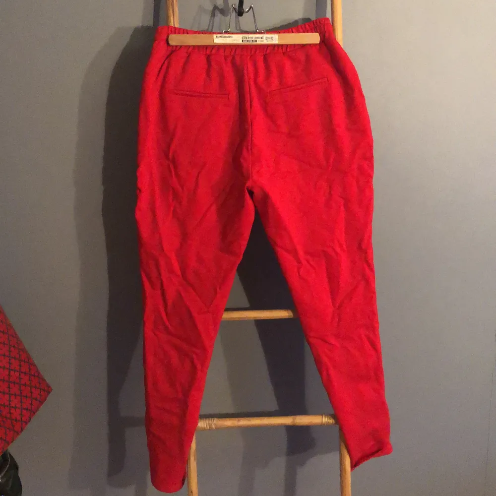 Röda Sweatpants med detaljer på sidan storlek 38.  Fickor fram och låtsats fickor bak. Använda en gång så i nysckick. Käns väldigt lyxiga. . Jeans & Byxor.