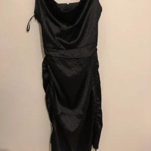 Satinklänning - Svart satinklänning från prettylittlething i strl S, knytning på båda höfterna för att justera längd och aldrig oanvänd!
