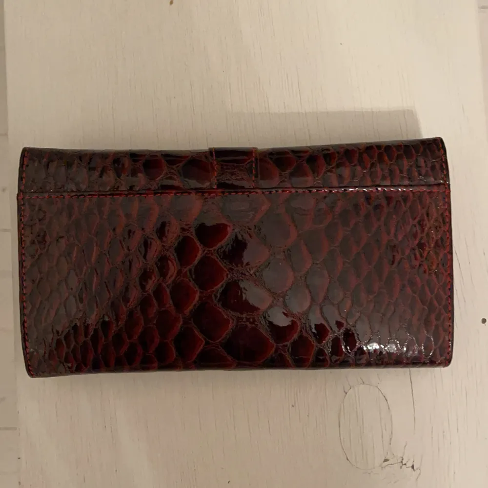 Plånbok som glänser i orm mönster, helt oanvänd. Säljer för 50kr. . Väskor.