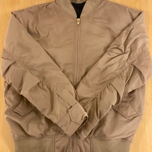 Filippa K Bentley bomber jacket - Nypris 2500. På rea på boozt nu för 1750 kr. Bud från 500. Sparsamt använd pga lite för stor för mig. Är en M men tycker den känns som en L. Bild 2 för att visa färgen bättre. Köpare står för frakt 